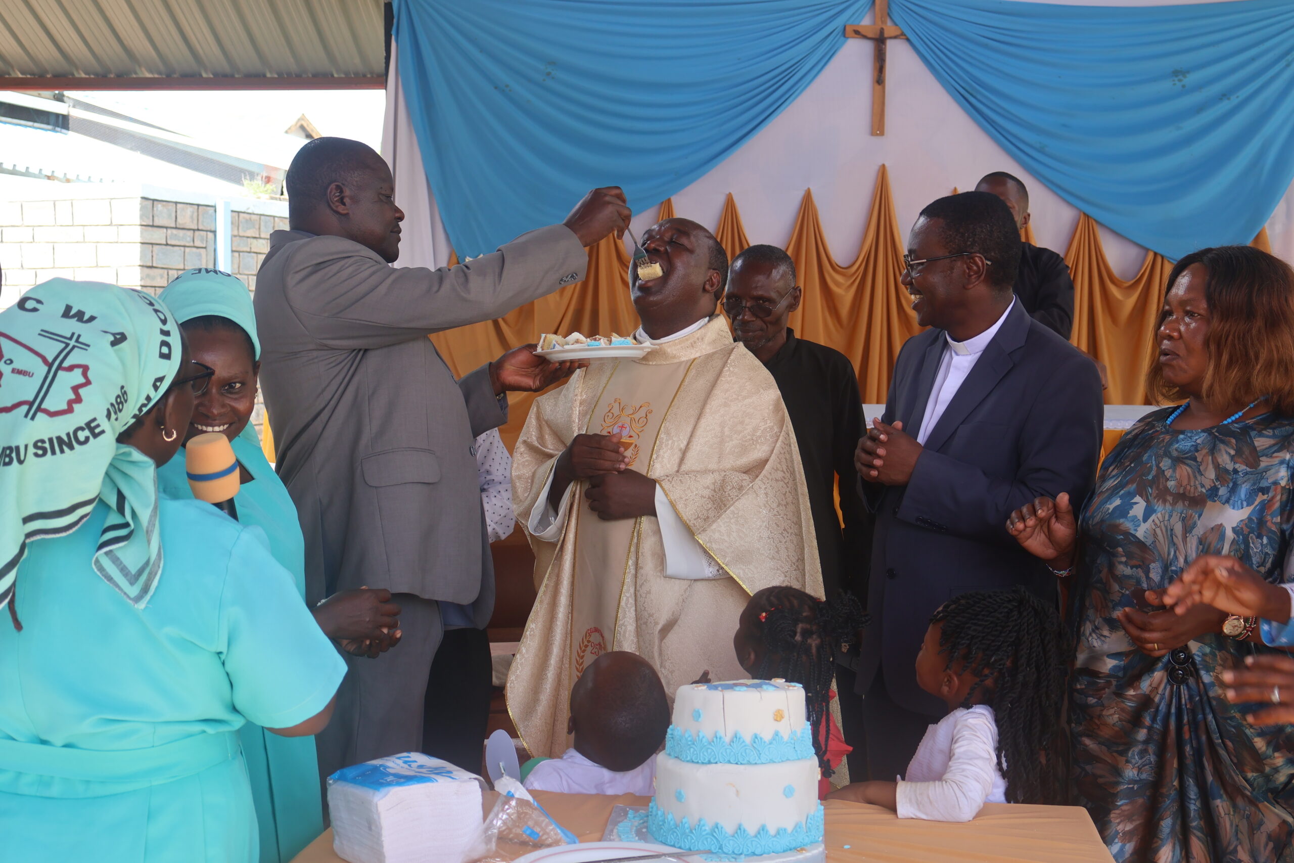 Diocese of Embu Communications Coordinator Rev. Fr. James Gatiti receives a cake from fellow jubilant Rev. Fr. Jeremiah Kinyua at Iriamurai Parish on 20th December 2025